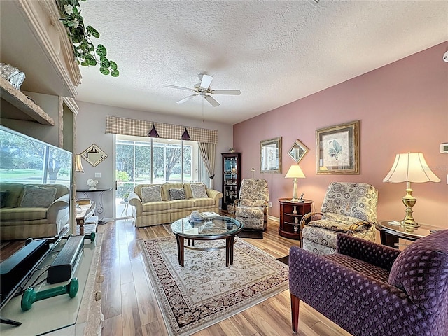 2415 Twickingham Ct, Clermont, FL 34711 - living room with a ceiling fan, a textured ceiling, wood finished floors, and baseboards
