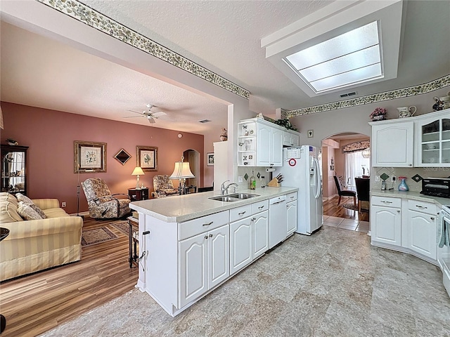 2415 Twickingham Ct, Clermont, FL 34711 - kitchen with open floor plan, a sink, arched walkways, white appliances, and ceiling fan
