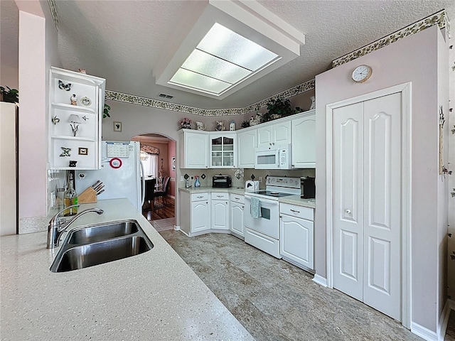 2415 Twickingham Ct, Clermont, FL 34711 - kitchen with white appliances, a sink, arched walkways, white cabinetry, and open shelves