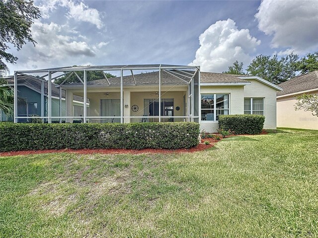 2415 Twickingham Ct, Clermont, FL 34711 - rear view of house featuring a ceiling fan, stucco siding, a yard, and a lanai