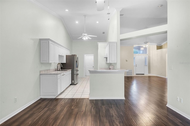 8527 Firestone Cir, Clermont, FL 34711 - kitchen featuring ceiling fan, a sink, light countertops, baseboards, and high vaulted ceiling