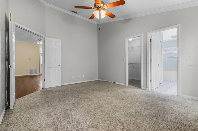 8527 Firestone Cir, Clermont, FL 34711 - unfurnished bedroom featuring carpet flooring, ornamental molding, a walk in closet, baseboards, and a closet