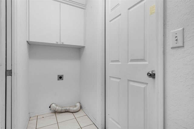 8527 Firestone Cir, Clermont, FL 34711 - laundry room featuring electric dryer hookup, cabinet space, light tile patterned floors, and baseboards