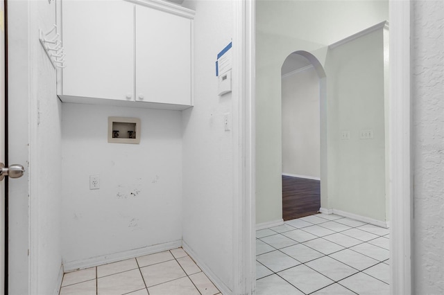 8527 Firestone Cir, Clermont, FL 34711 - laundry room with cabinet space, washer hookup, arched walkways, and light tile patterned floors