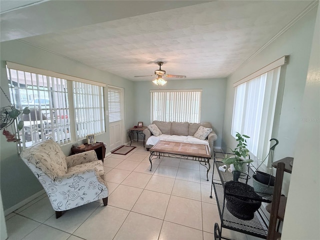 603 W Seminole Ave, Eustis, FL 32726 - living area with healthy amount of natural light, light tile patterned flooring, a ceiling fan, and baseboards
