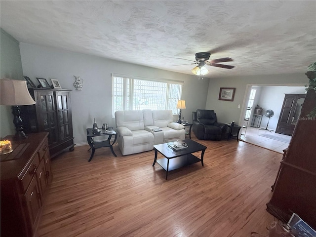 603 W Seminole Ave, Eustis, FL 32726 - living area with light wood-type flooring, ceiling fan, a textured ceiling, and baseboards