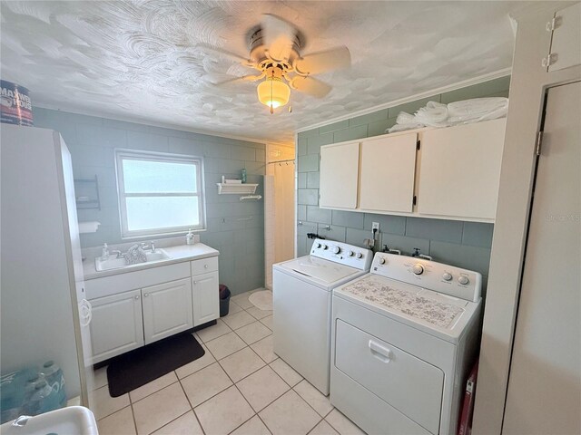 603 W Seminole Ave, Eustis, FL 32726 - washroom featuring cabinet space, washing machine and dryer, light tile patterned flooring, tile walls, and ceiling fan