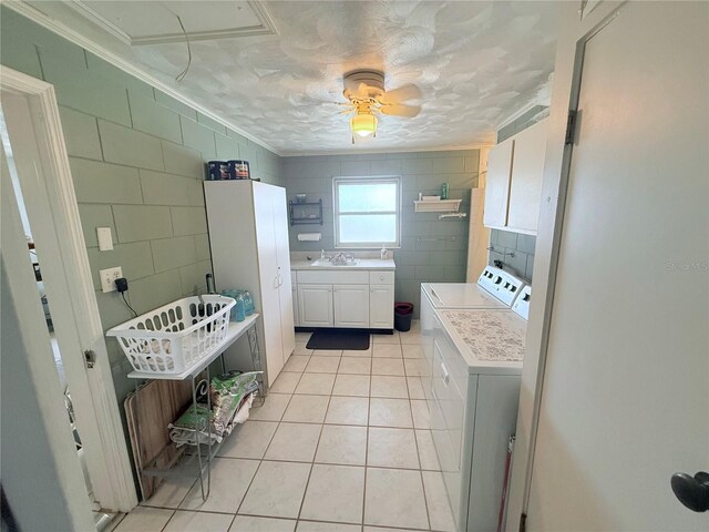 603 W Seminole Ave, Eustis, FL 32726 - clothes washing area featuring cabinet space, crown molding, washer and dryer, light tile patterned flooring, and tile walls