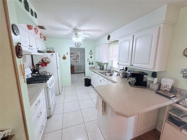 603 W Seminole Ave, Eustis, FL 32726 - kitchen featuring white gas stove, under cabinet range hood, ceiling fan, light countertops, and a peninsula