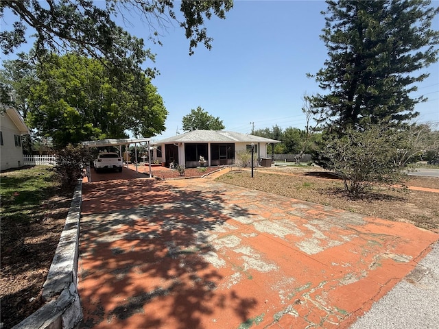 603 W Seminole Ave, Eustis, FL 32726 - rear view of house with concrete driveway, a carport, and fence