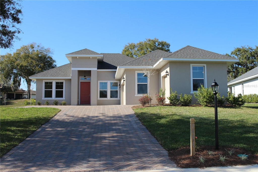 0 Spinnaker Loop, Lady Lake, FL 32159 - view of front of property featuring stucco siding, a front lawn, and roof with shingles