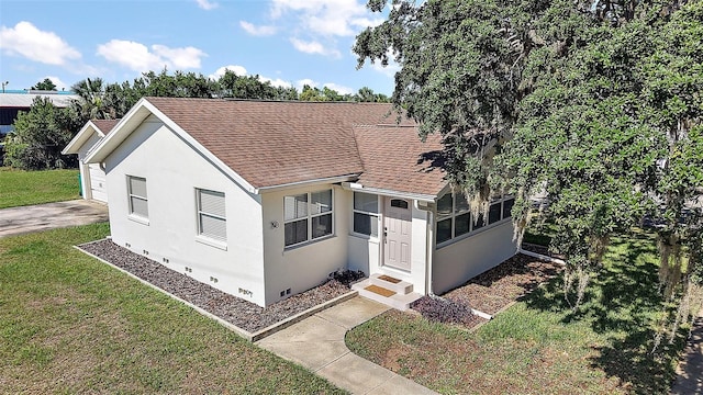 30 E Key Ave, Eustis, FL 32726 - view of front of home with a shingled roof, a front lawn, stucco siding, a sunroom, and crawl space