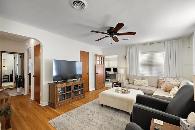 30 E Key Ave, Eustis, FL 32726 - living area featuring arched walkways, ceiling fan, light wood-style flooring, and baseboards