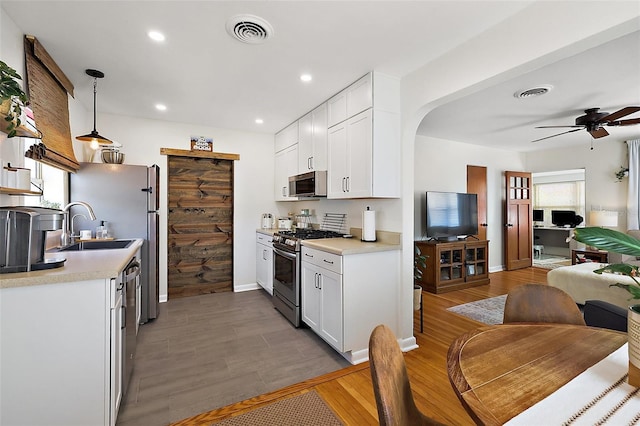 30 E Key Ave, Eustis, FL 32726 - kitchen featuring appliances with stainless steel finishes, open floor plan, light countertops, white cabinetry, and recessed lighting