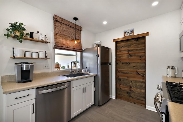 30 E Key Ave, Eustis, FL 32726 - kitchen featuring appliances with stainless steel finishes, a sink, light countertops, white cabinets, and decorative light fixtures