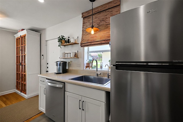30 E Key Ave, Eustis, FL 32726 - kitchen featuring appliances with stainless steel finishes, a sink, wood finished floors, light countertops, and open shelves
