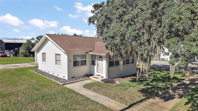 30 E Key Ave, Eustis, FL 32726 - bungalow-style home with a front yard, stucco siding, a shingled roof, and entry steps
