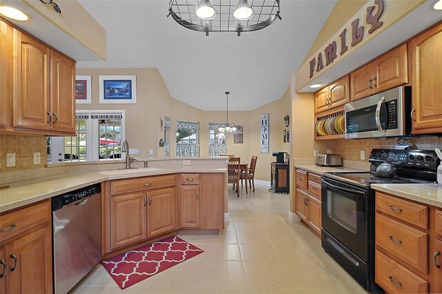 397 Anderson Dr, Tavares, FL 32778 - kitchen featuring stainless steel appliances, a sink, a chandelier, a peninsula, and tasteful backsplash