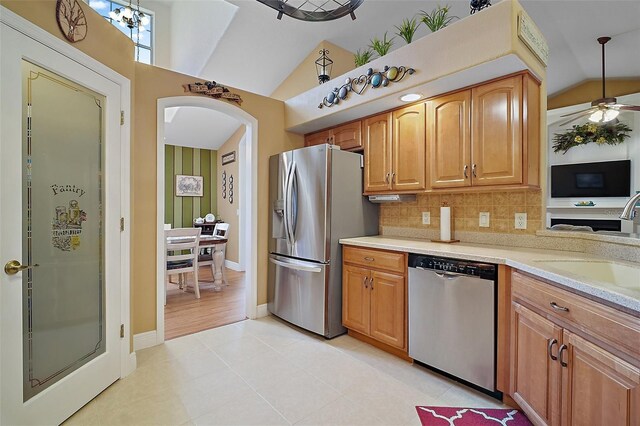 397 Anderson Dr, Tavares, FL 32778 - kitchen featuring stainless steel appliances, lofted ceiling, a sink, arched walkways, and light tile patterned floors