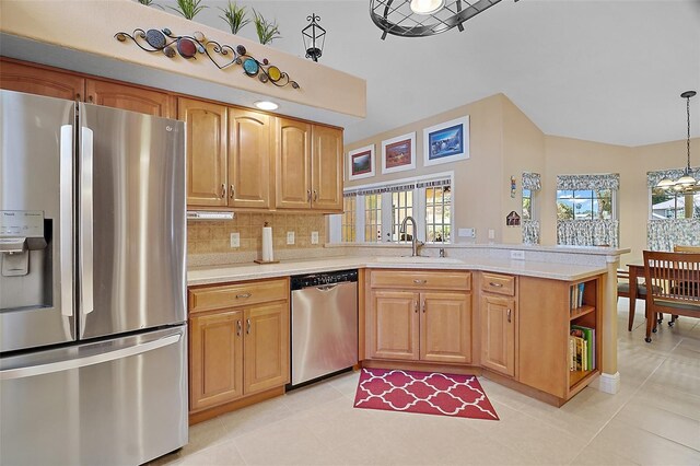 397 Anderson Dr, Tavares, FL 32778 - kitchen featuring appliances with stainless steel finishes, a sink, a peninsula, light countertops, and vaulted ceiling