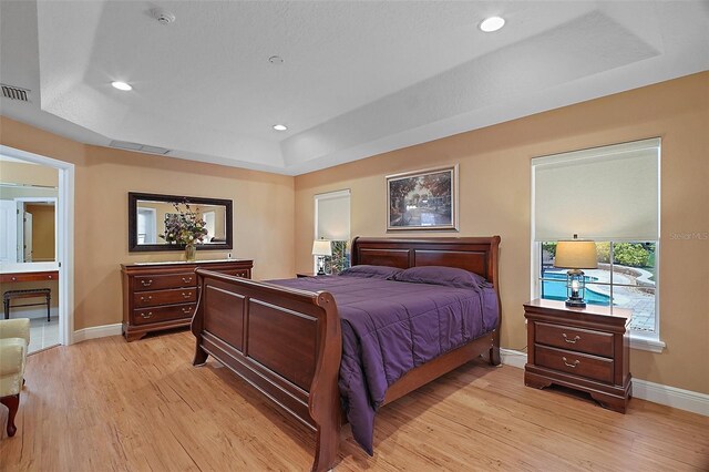397 Anderson Dr, Tavares, FL 32778 - bedroom featuring a tray ceiling, baseboards, light wood finished floors, and recessed lighting