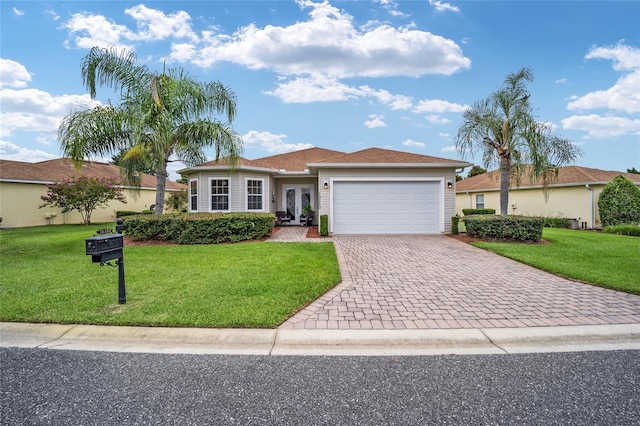 single story home featuring french doors, an attached garage, driveway, and a front yard
