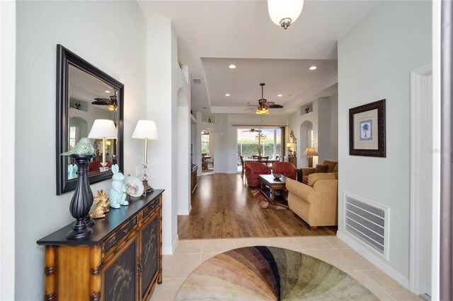 living room featuring a ceiling fan, light tile patterned floors, arched walkways, recessed lighting, and baseboards