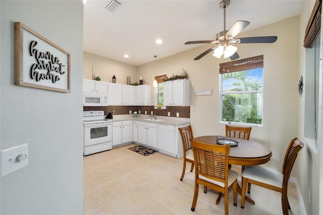 kitchen with white appliances, tasteful backsplash, white cabinetry, a ceiling fan, and light countertops