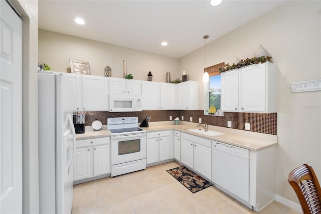 kitchen with white appliances, a sink, decorative backsplash, white cabinets, and recessed lighting