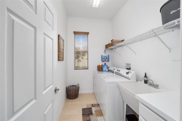 laundry room featuring independent washer and dryer, light tile patterned floors, and baseboards