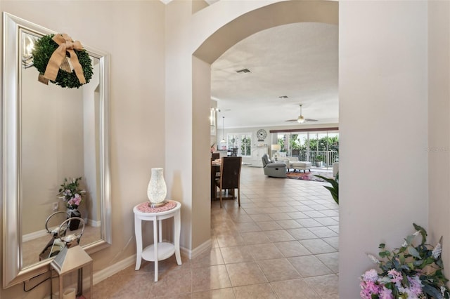 17108 SE 76th Creekside Cir, The Villages, FL 32162 - hall with arched walkways, light tile patterned floors, and baseboards