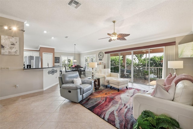 17108 SE 76th Creekside Cir, The Villages, FL 32162 - living room with ornamental molding, baseboards, ceiling fan, a textured ceiling, and light tile patterned floors