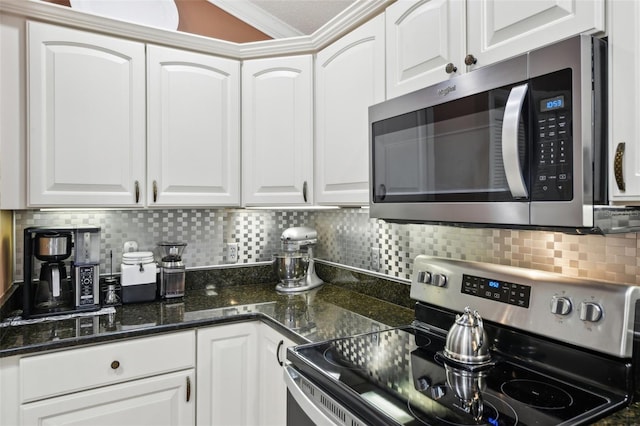 17108 SE 76th Creekside Cir, The Villages, FL 32162 - kitchen with stainless steel appliances, crown molding, white cabinets, backsplash, and dark stone countertops