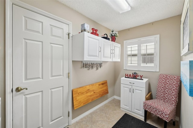 17108 SE 76th Creekside Cir, The Villages, FL 32162 - laundry room featuring a textured ceiling, light tile patterned floors, and baseboards