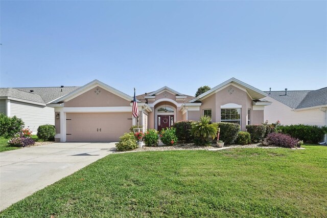 17108 SE 76th Creekside Cir, The Villages, FL 32162 - view of front of house featuring stucco siding, a garage, a front lawn, and concrete driveway