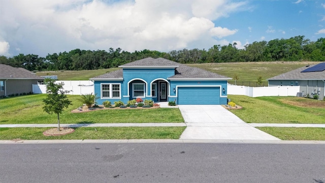 view of front facade with an attached garage, driveway, and stucco siding