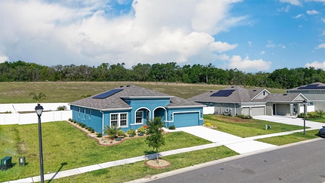 ranch-style house with a garage, solar panels, driveway, stucco siding, and a shingled roof