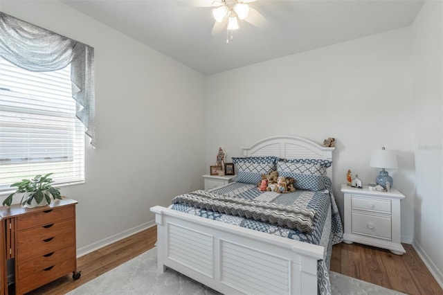 bedroom with light wood-style flooring, baseboards, and ceiling fan