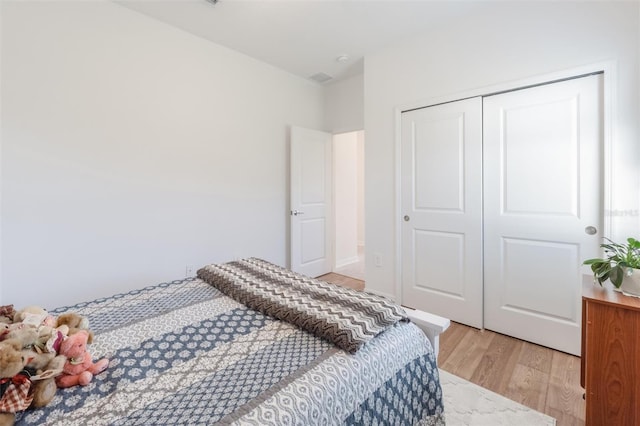 bedroom with light wood-type flooring and a closet