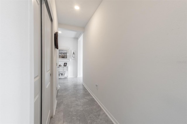 hall featuring baseboards and recessed lighting