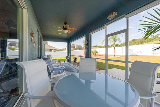 sunroom / solarium featuring ceiling fan, a water view, and outdoor dining area