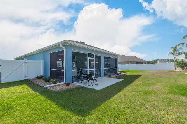 back of house with a sunroom, a gate, a patio area, and stucco siding