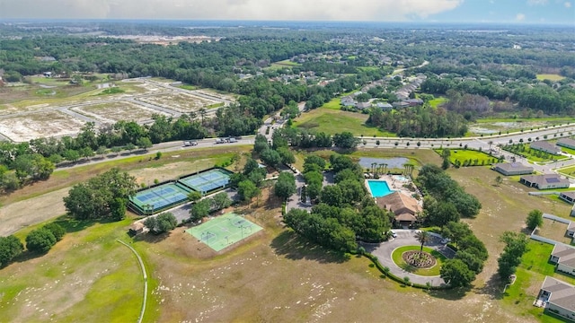 aerial view of property's location with a pool area and a heavily wooded area