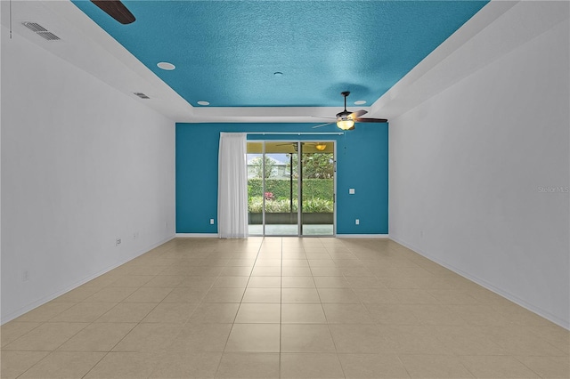 2424 Plumadore Dr, Grand Island, FL 32735 - unfurnished room featuring a ceiling fan, a raised ceiling, a textured ceiling, and baseboards