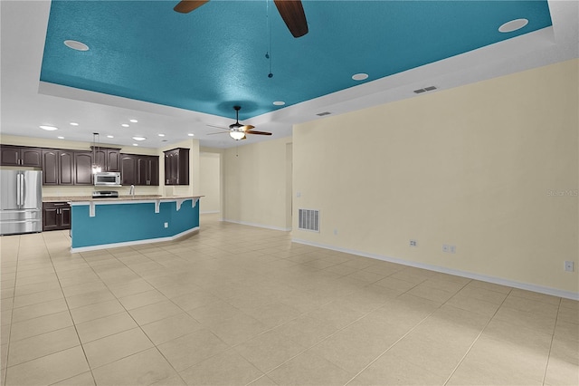 2424 Plumadore Dr, Grand Island, FL 32735 - unfurnished living room with a raised ceiling, a ceiling fan, recessed lighting, light tile patterned floors, and baseboards