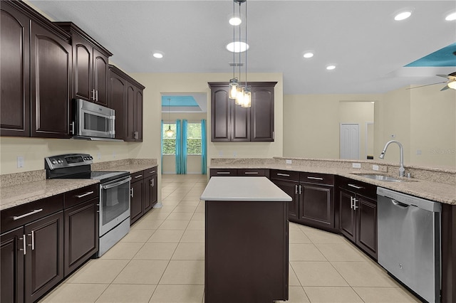 2424 Plumadore Dr, Grand Island, FL 32735 - kitchen with appliances with stainless steel finishes, a sink, a center island, light tile patterned floors, and dark brown cabinetry