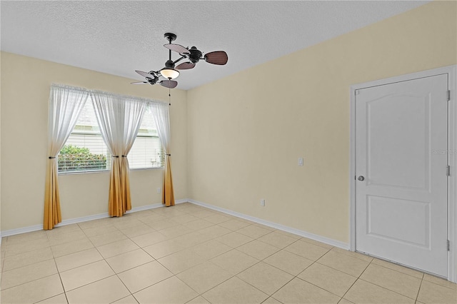 2424 Plumadore Dr, Grand Island, FL 32735 - spare room featuring a ceiling fan, a textured ceiling, baseboards, and light tile patterned floors