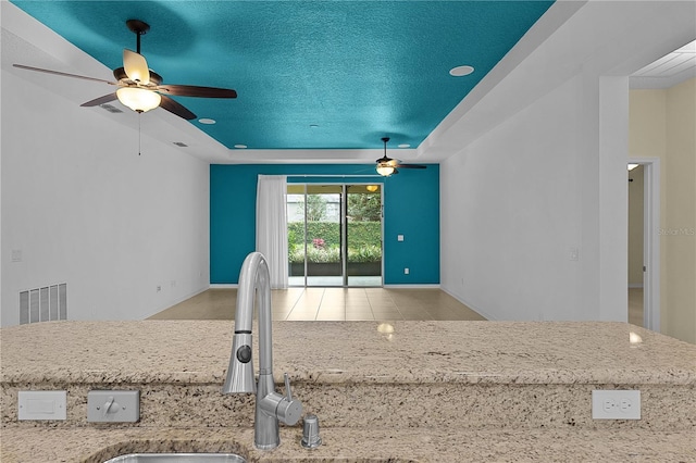 2424 Plumadore Dr, Grand Island, FL 32735 - kitchen featuring ceiling fan, a raised ceiling, a sink, baseboards, and a textured ceiling