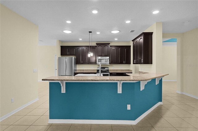 2424 Plumadore Dr, Grand Island, FL 32735 - kitchen with stainless steel appliances, a kitchen breakfast bar, light tile patterned floors, dark brown cabinets, and recessed lighting