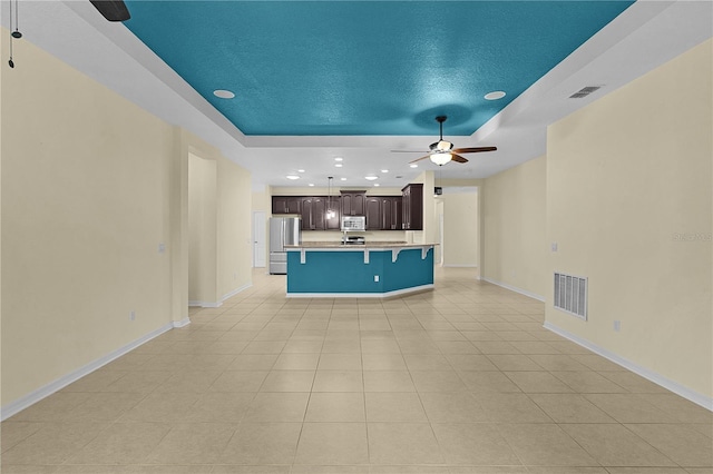 2424 Plumadore Dr, Grand Island, FL 32735 - unfurnished living room with a raised ceiling, ceiling fan, recessed lighting, baseboards, and light tile patterned floors